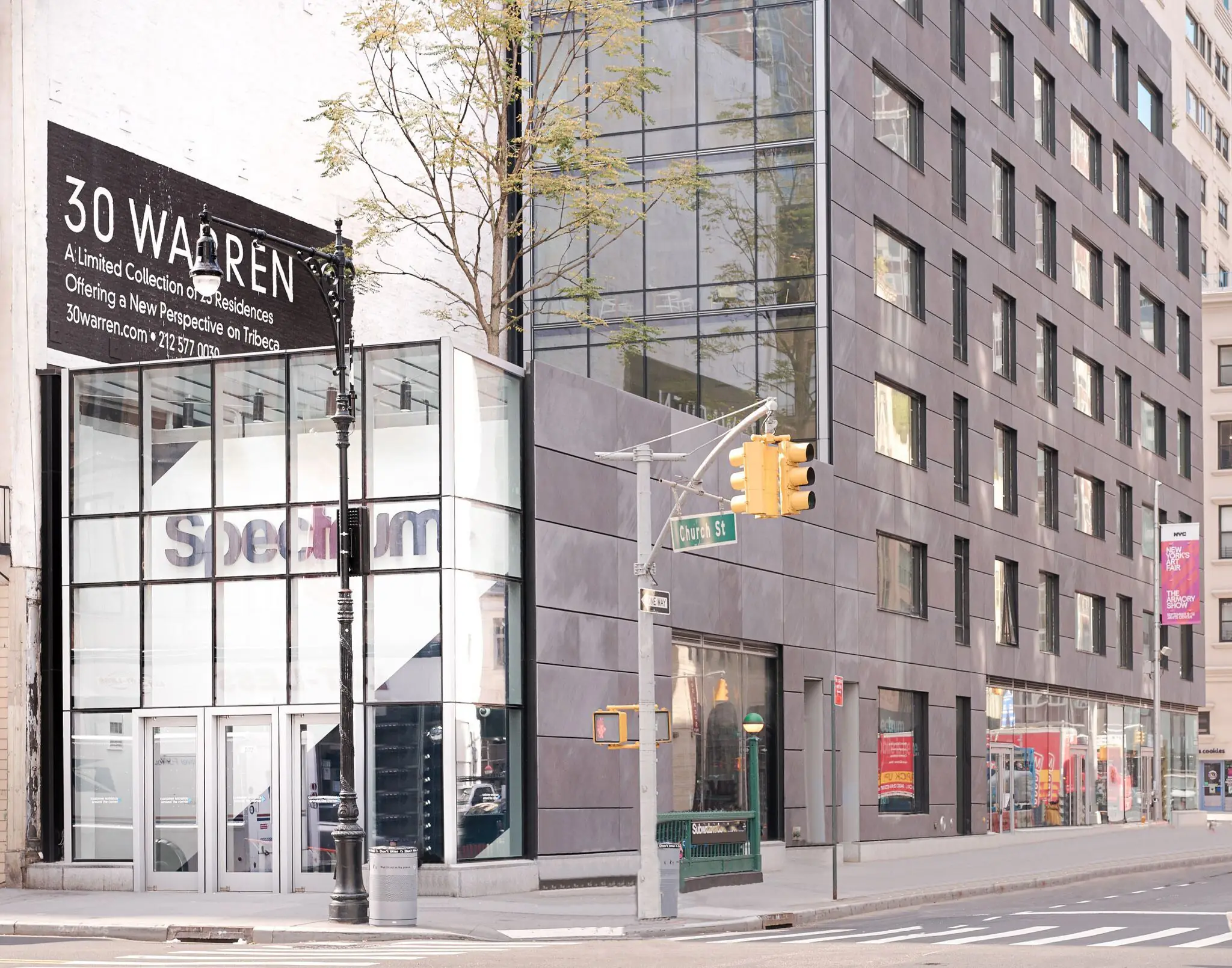 Street-level retail frontage and contemporary stone-clad facade at 30 Warren St in Tribeca